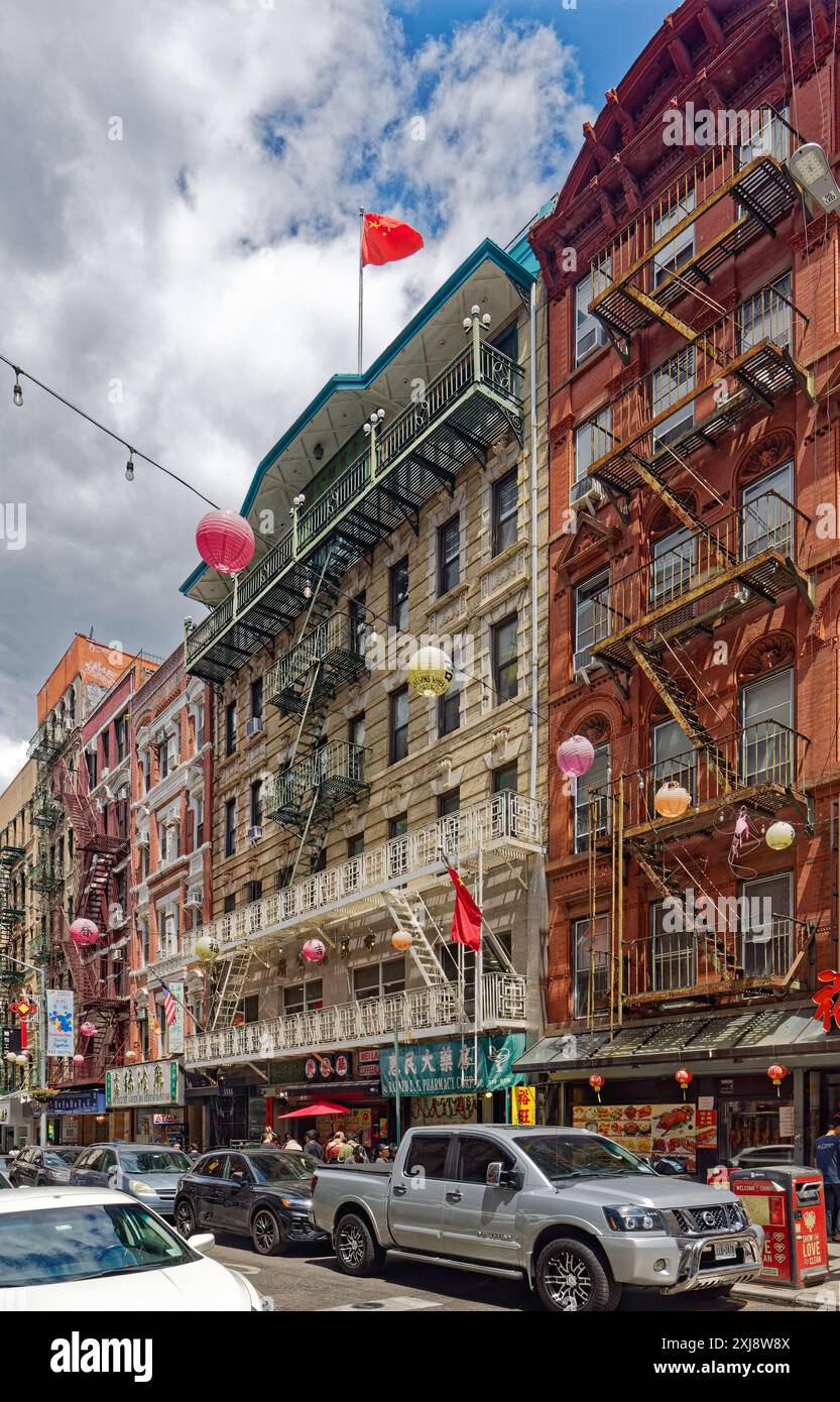 NYC Chinatown: Chinese flags fly at 62-64 Bayard Street, Gee How Oak Tin Association building; iron balconies at second, third, and top floors. Stock Photo