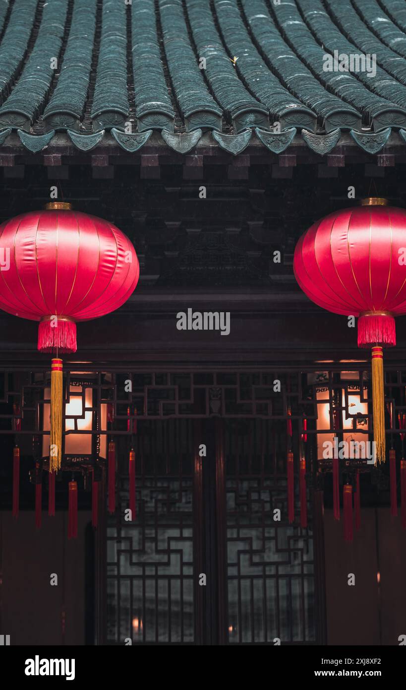 Two red lanterns hang from the eaves of a traditional Chinese building ...