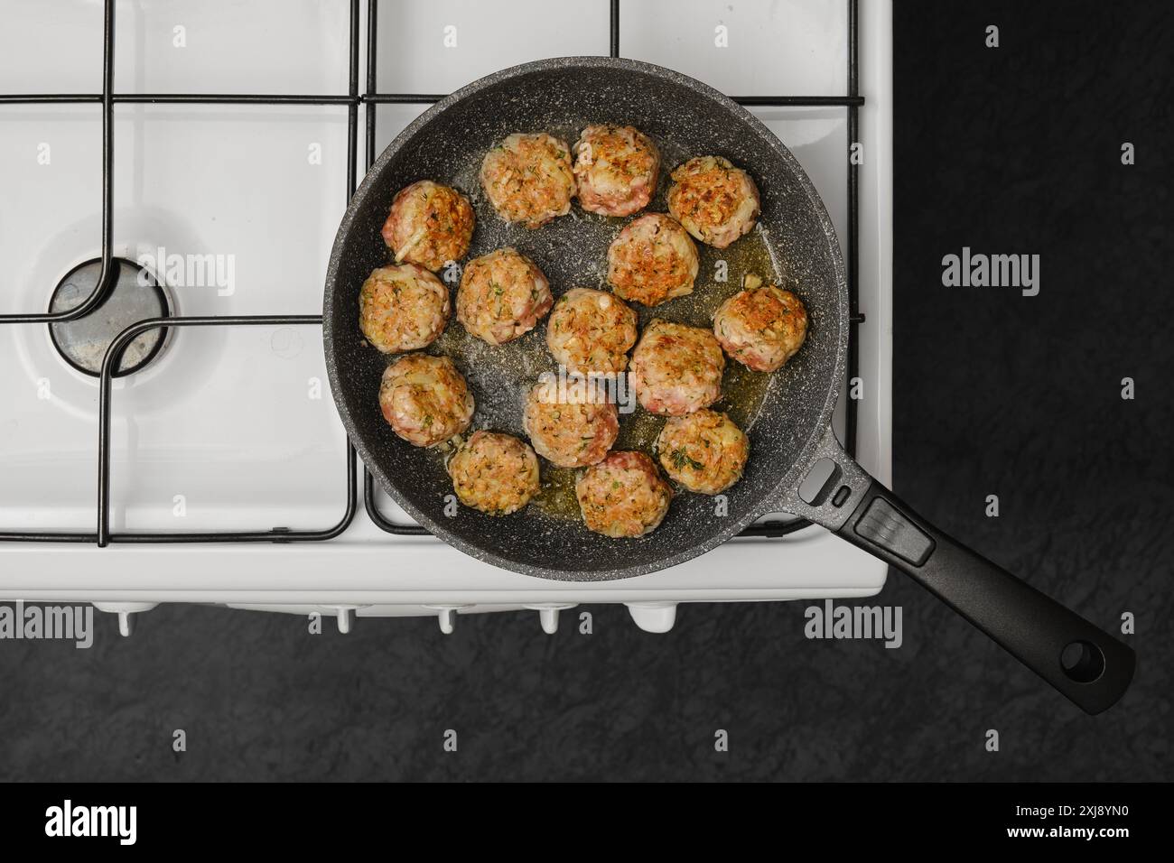 Top view of cooking meatballs in frying pan with olive oil on a gas stove Stock Photo