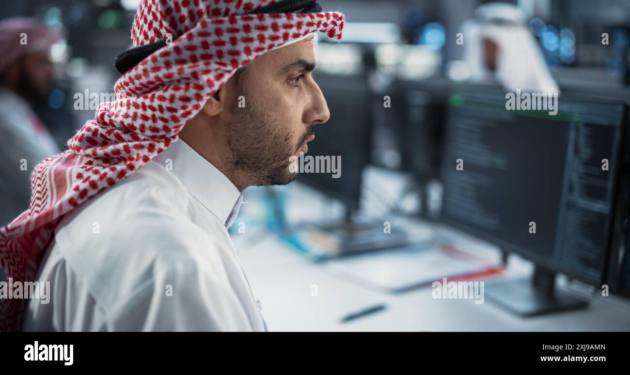 Portrait of a Middle Eastern Engineer Working on Desktop Computer in a Technological Office Environment. Arab Software Developer Researching New Ideas to Problem Solve a Technical Assignment Stock Photo