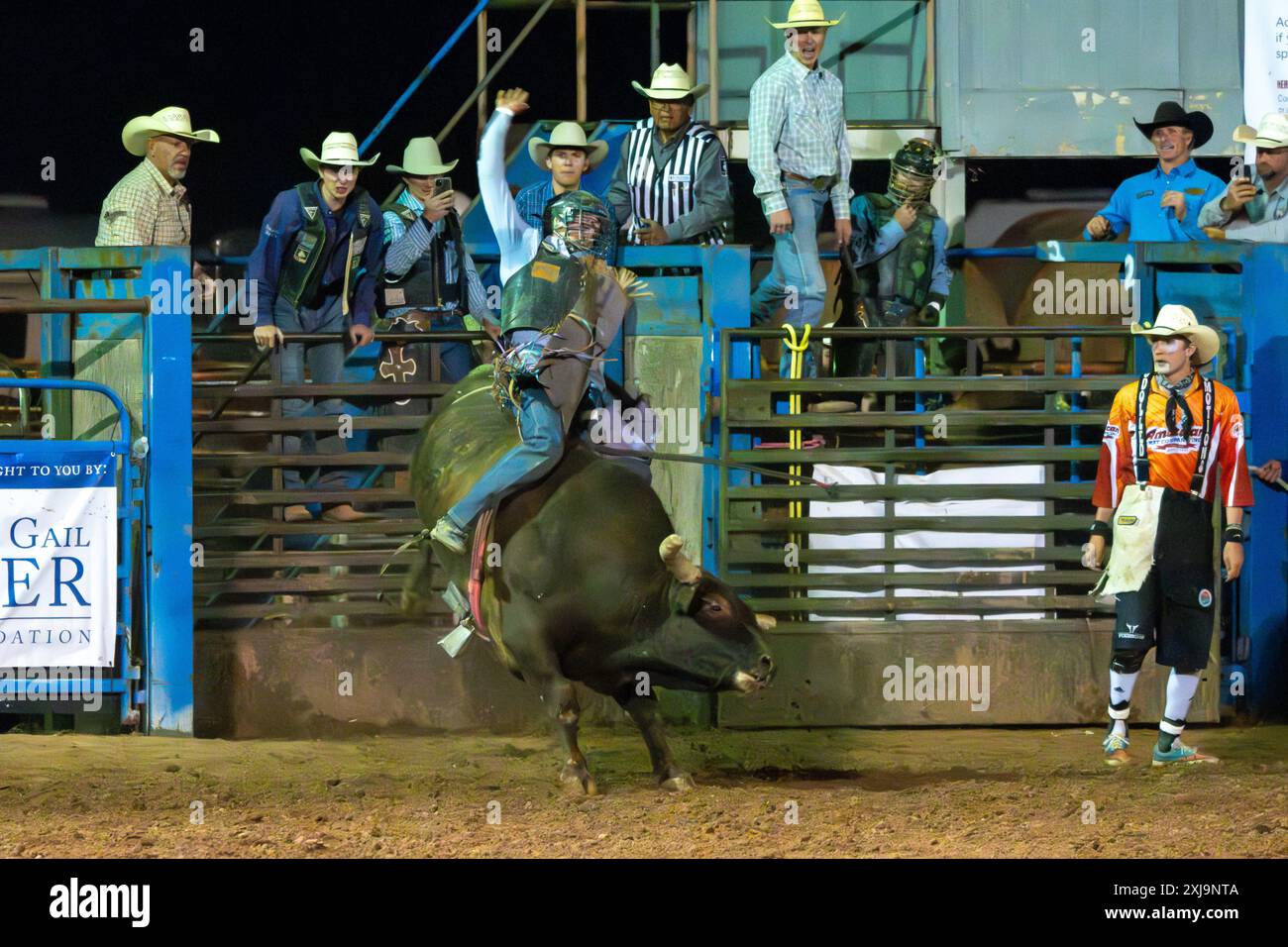 A professional rodeo cowboy rides a bull in a rodeo in a small town in rural Utah. Stock Photo