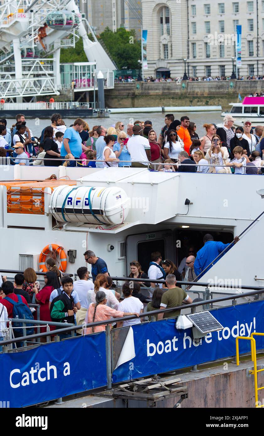 People queue and wait for a boat ride in London as many tourists are ...