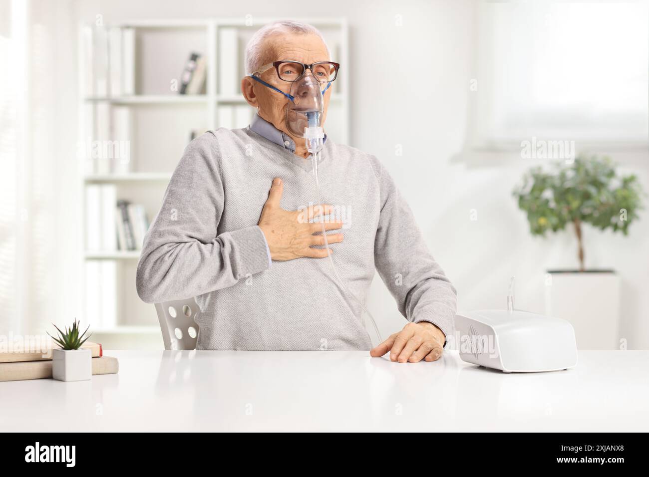 Elderly man with breathing problem using a nebulizer at home Stock Photo