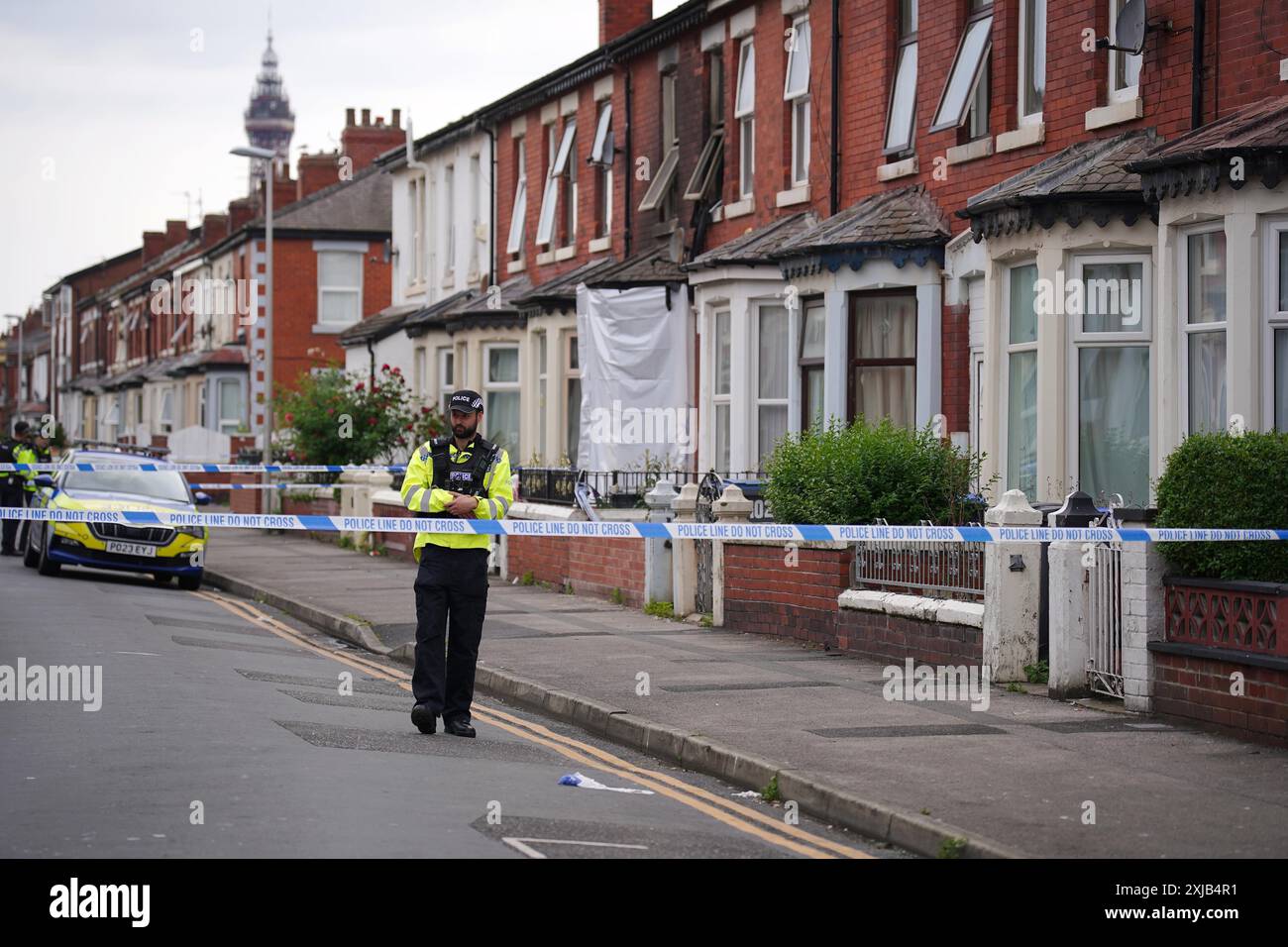 A police officer near a house in Blackpool after a man and a woman died ...