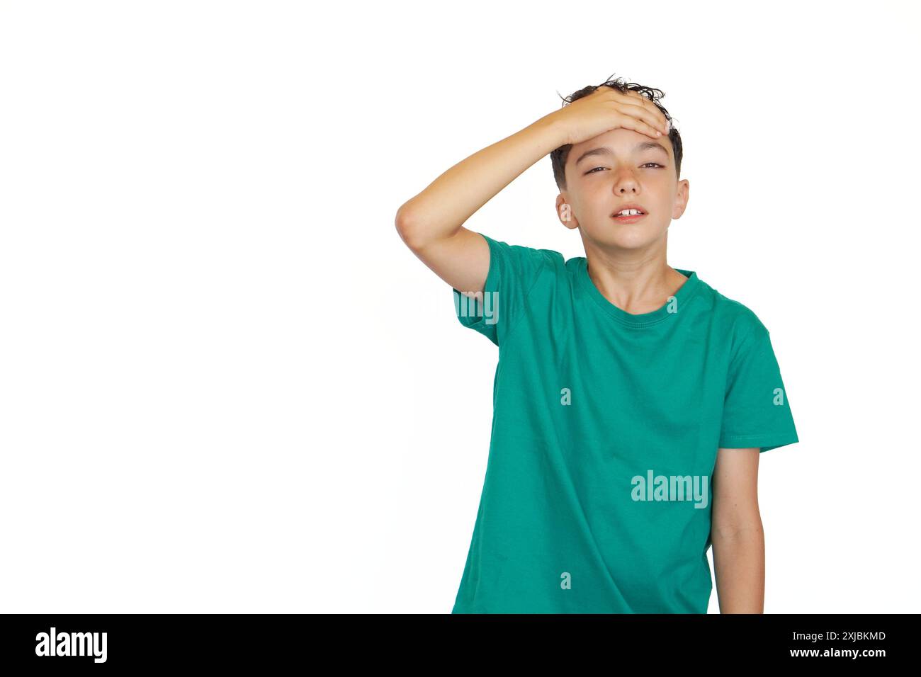 child preteen holding his hand to his forehead with a gesture of pain and exhaustion Stock Photo