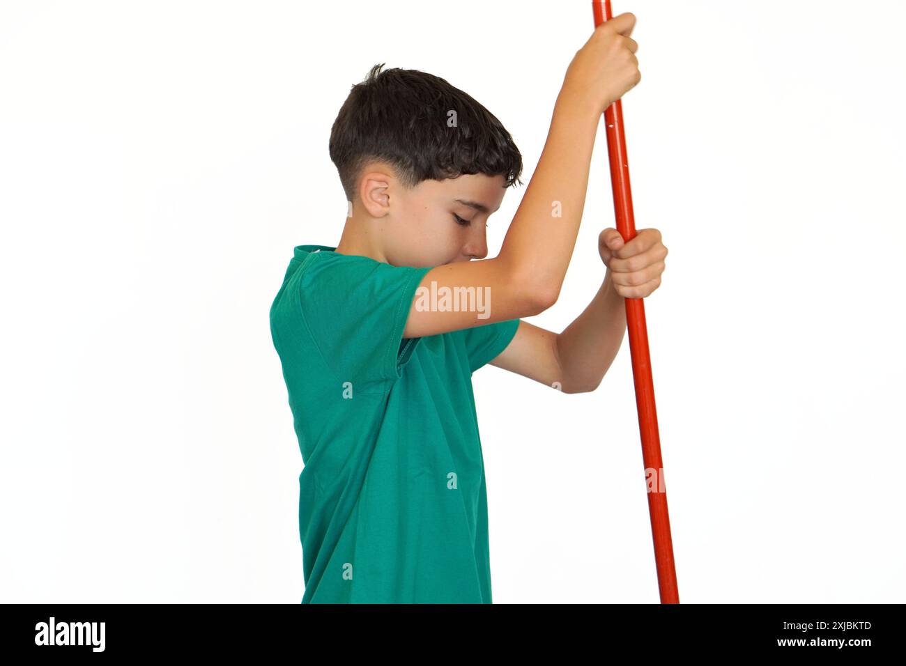 preteen boy on white background holding a red stick upright Stock Photo