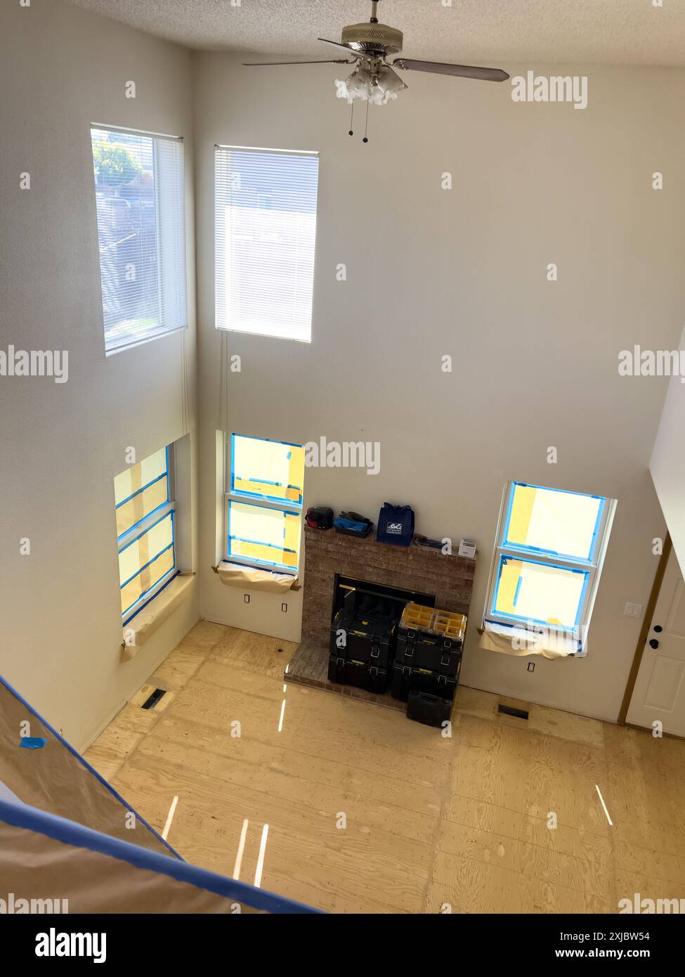 Curated visual reference: Small Apartment Renovation With Large Windows Reference: Two Story Living Room Undergoing Renovation With Fireplace And Large