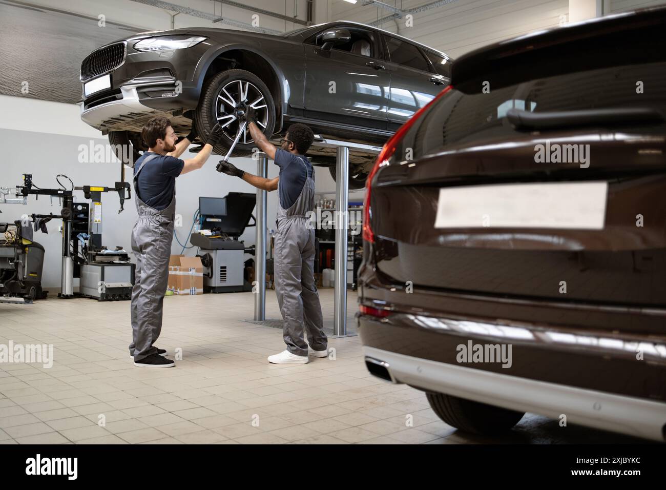 Mechanics working on car in auto repair shop Stock Photo - Alamy