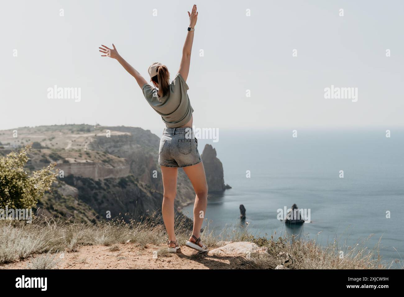Woman Celebrating Freedom on Clifftop Stock Photo