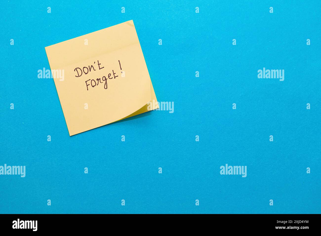 A simple yellow sticky note on blue, perfect for adding your reminder! Stock Photo