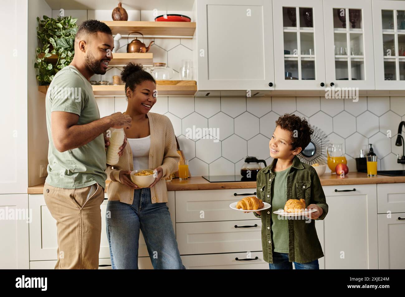 A man and woman cook in a kitchen with their child Stock Photo - Alamy