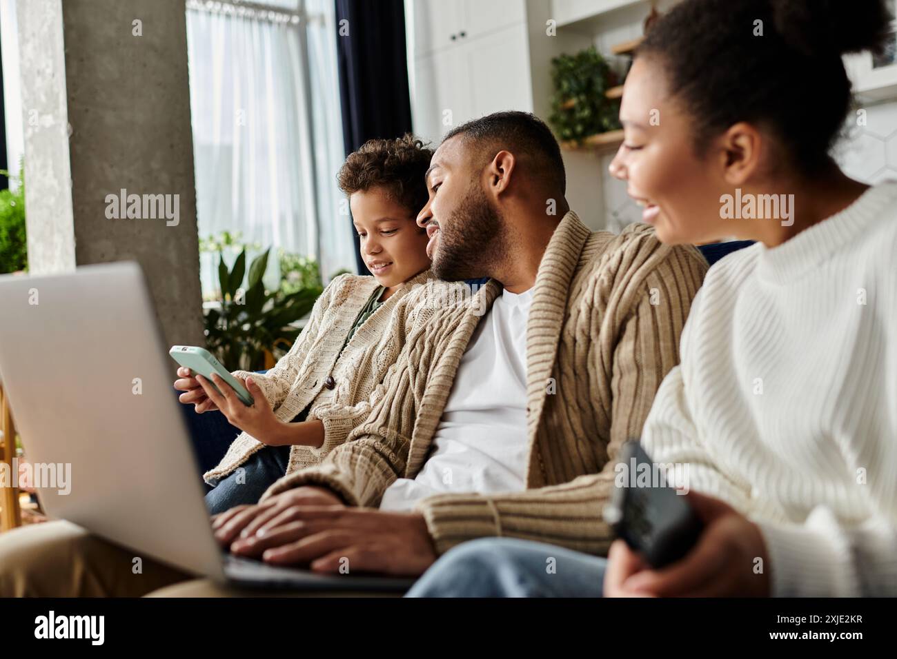 African american family engaged with laptop on couch Stock Photo - Alamy