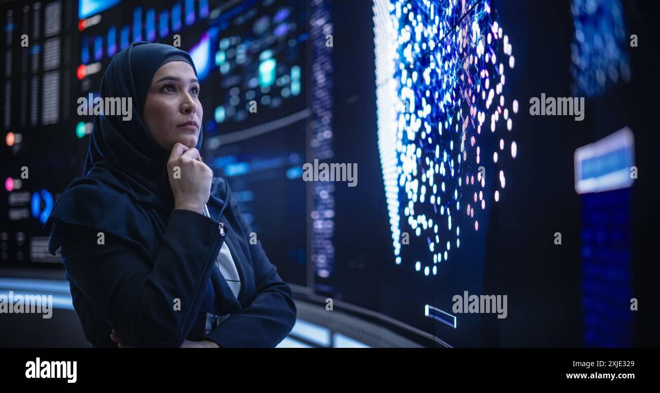 Portrait of a Thoughtful Middle Eastern Software Developer Working in Technological Corporate Office. Young Woman Testing Artificial Intelligence Algorithms for an Innovative Internet Project Stock Photo