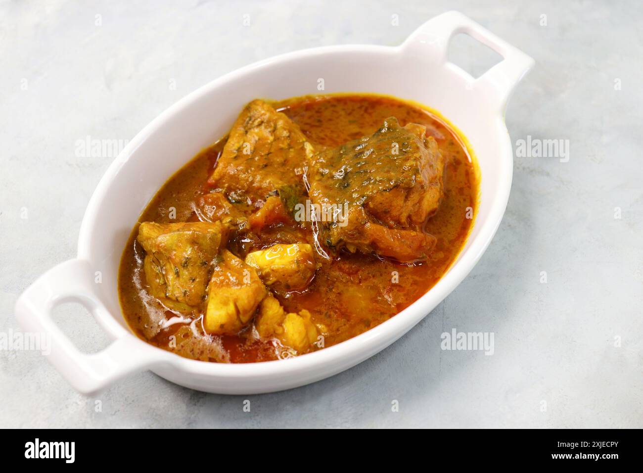 Indian Food. Homemade Spicy and tangy dadha or threadfin fish curry. Famous Maharashtrian red fish curry or kalvan is made with tomato and spices. Stock Photo