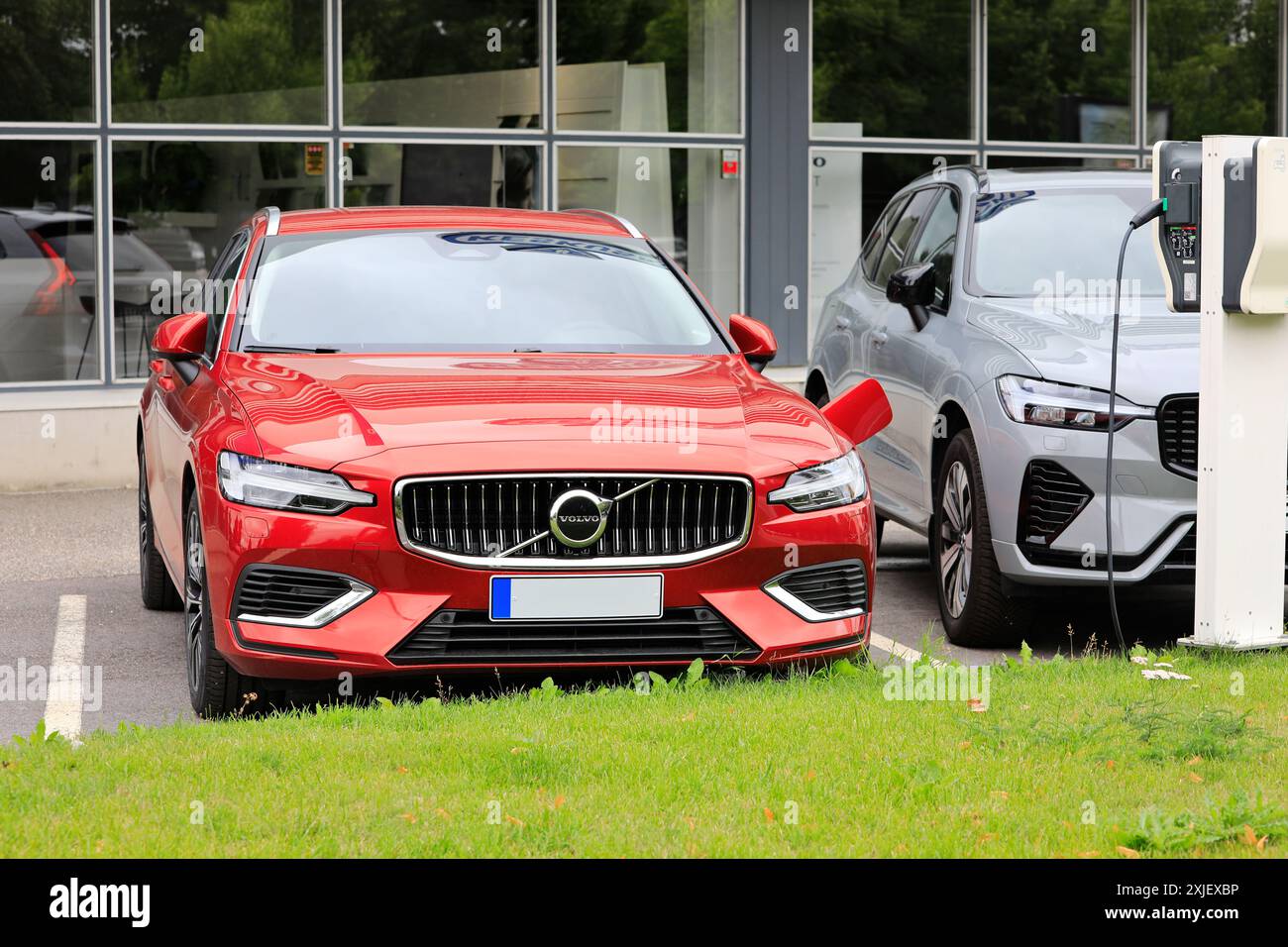 Red Volvo V60 (II) AWD 2024 hybrid electric car plugged in battery