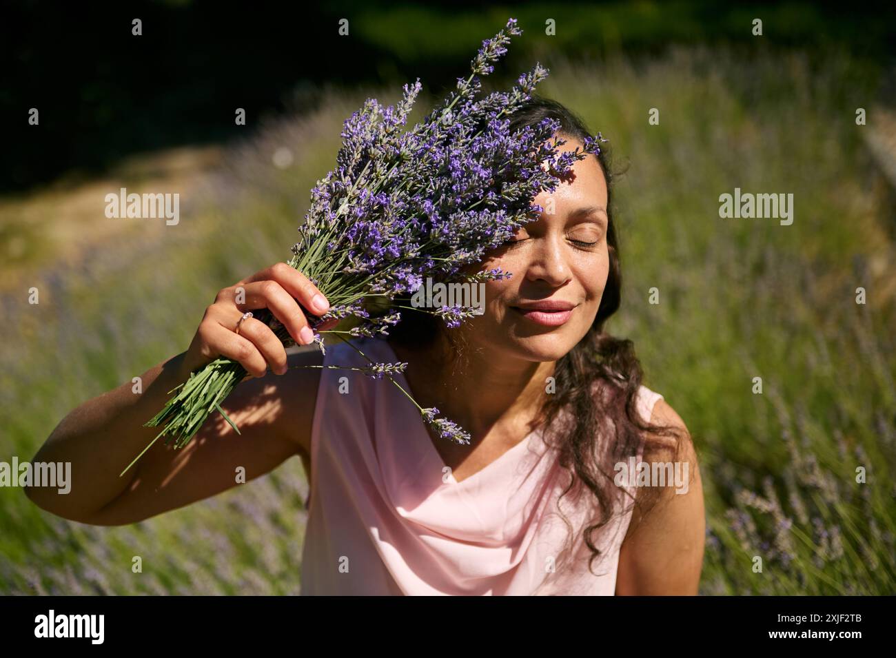 A serene woman embraces the beauty of a lavender field on a sunny day ...