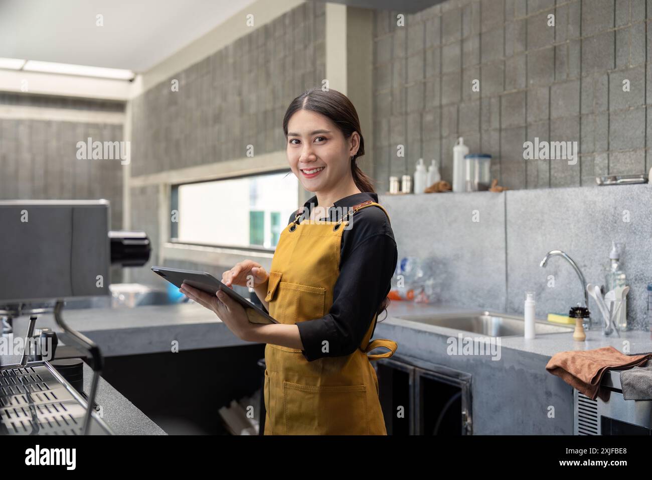 Young Barista in Modern Coffee Shop Holding Tablet and Smiling at ...