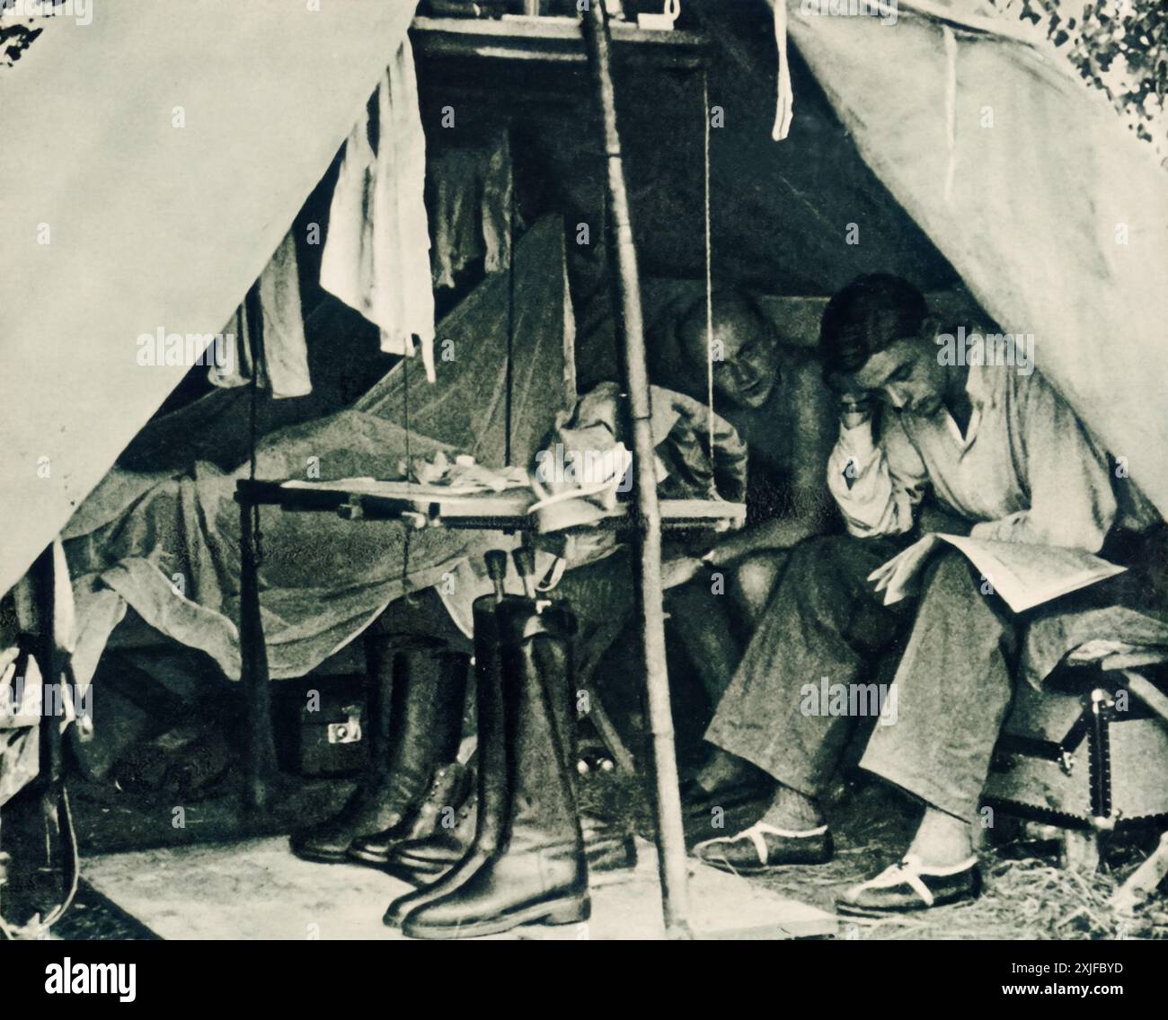 A photograph shows two German soldiers relaxing in their tent during a ...