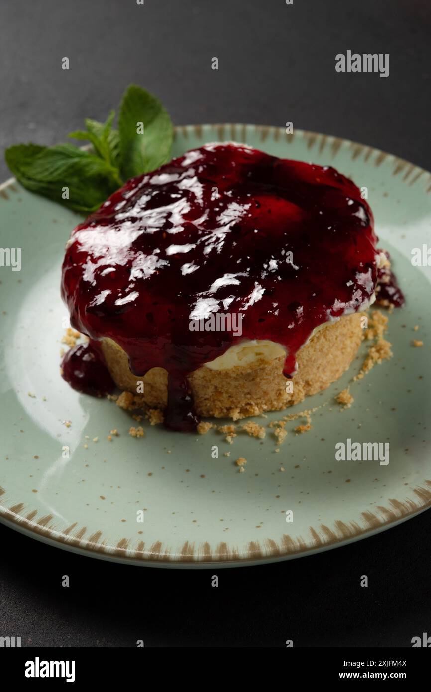 Home made mini Cheesecake on plate on dark background. Stock Photo