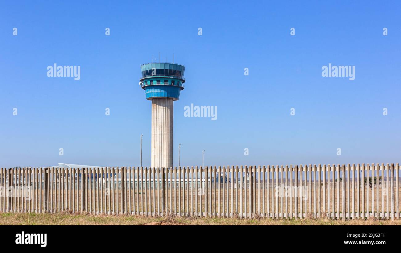 Airport traffic control tower in blue sky and boundary security fence ...