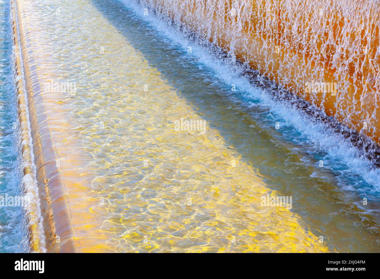 Water is flowing down a wall, creating a peaceful and calming atmosphere. Fountain with water cascade Stock Photo