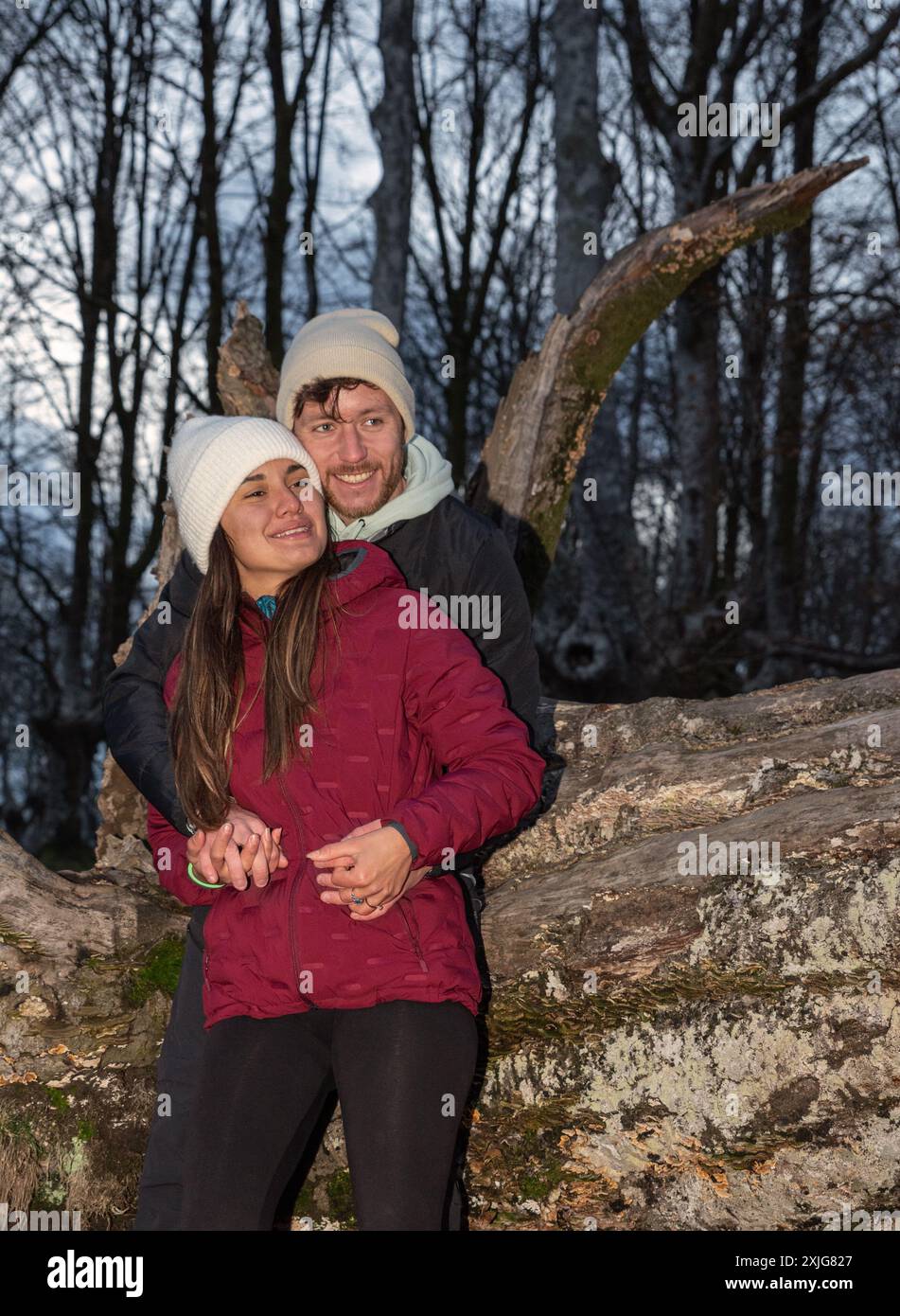 mountain couple hugging leaning on a log Stock Photo
