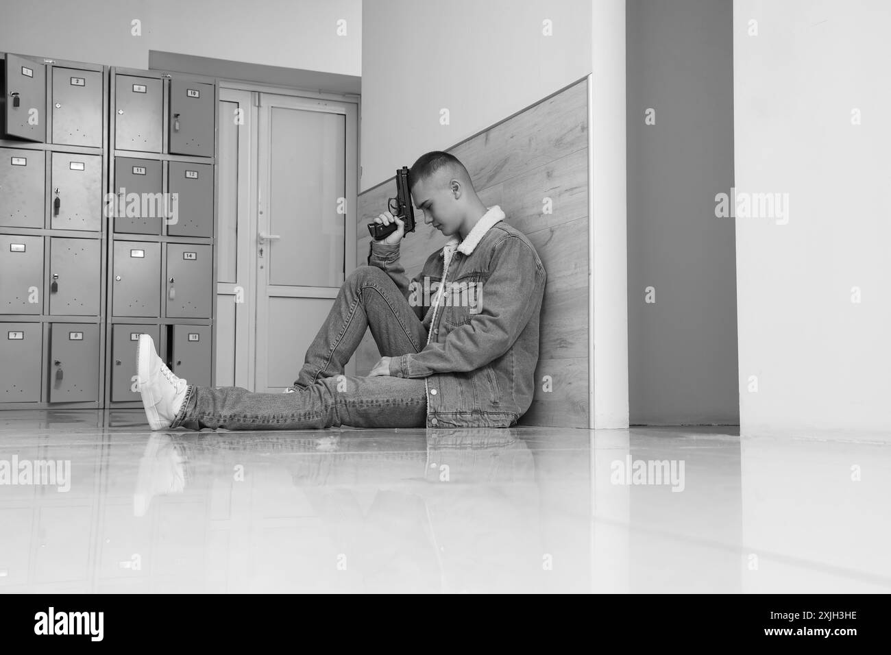 Male student with gun sitting at university hall Stock Photo - Alamy