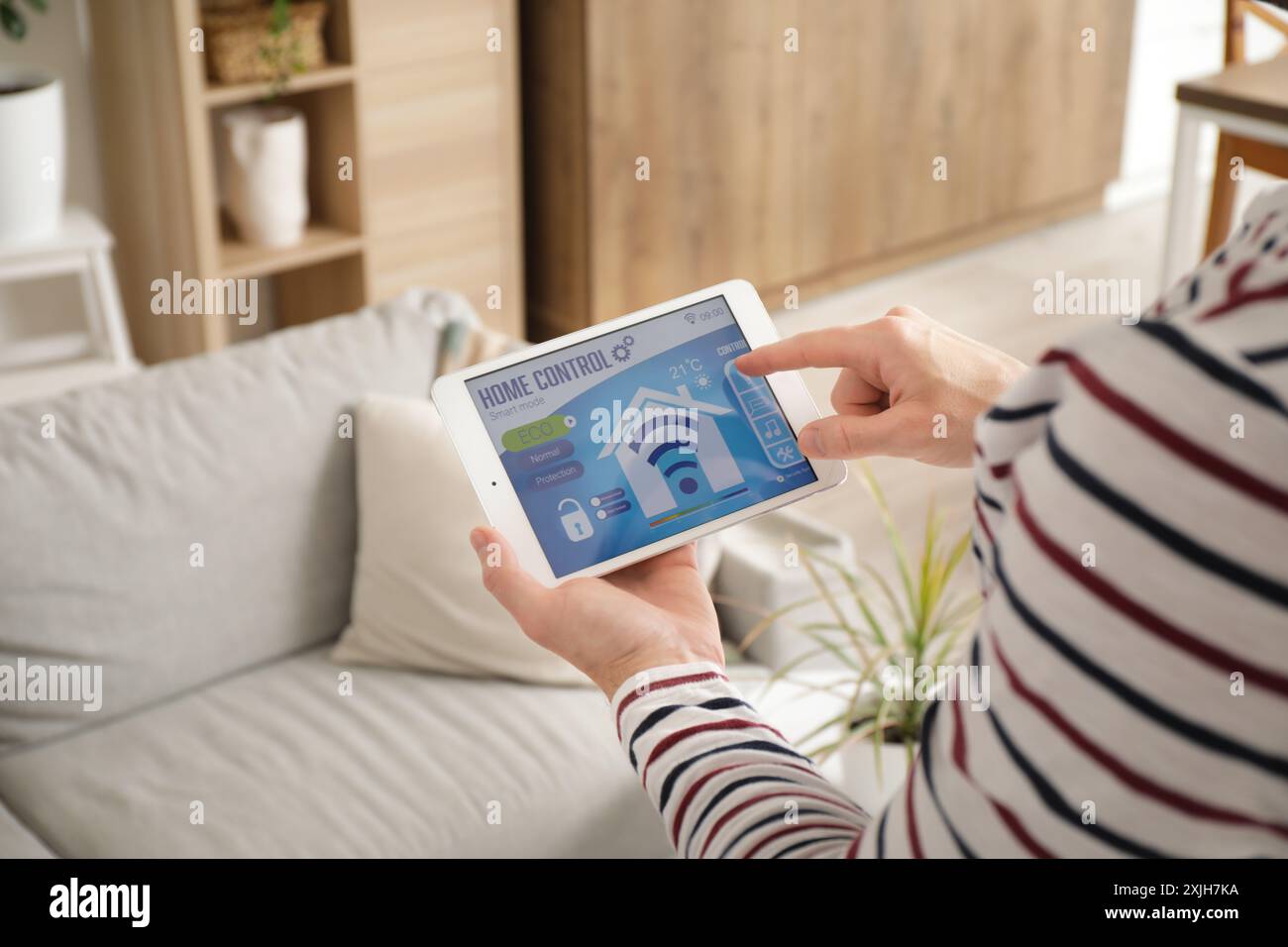 Young man using smart home security system control panel, closeup Stock Photo