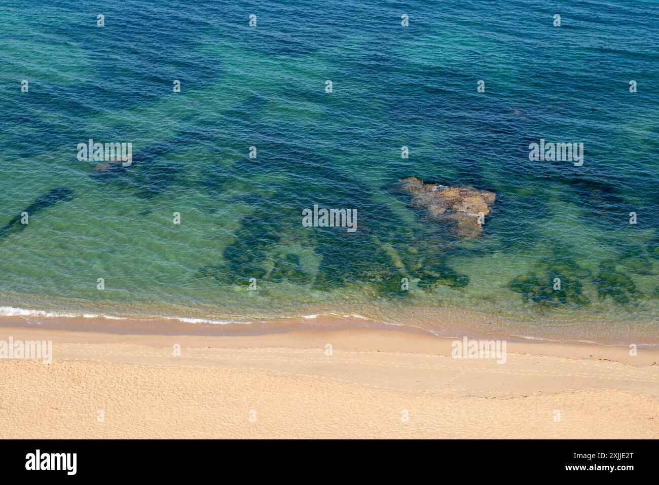 Soft blue ocean wave on clean sandy beach Stock Photo