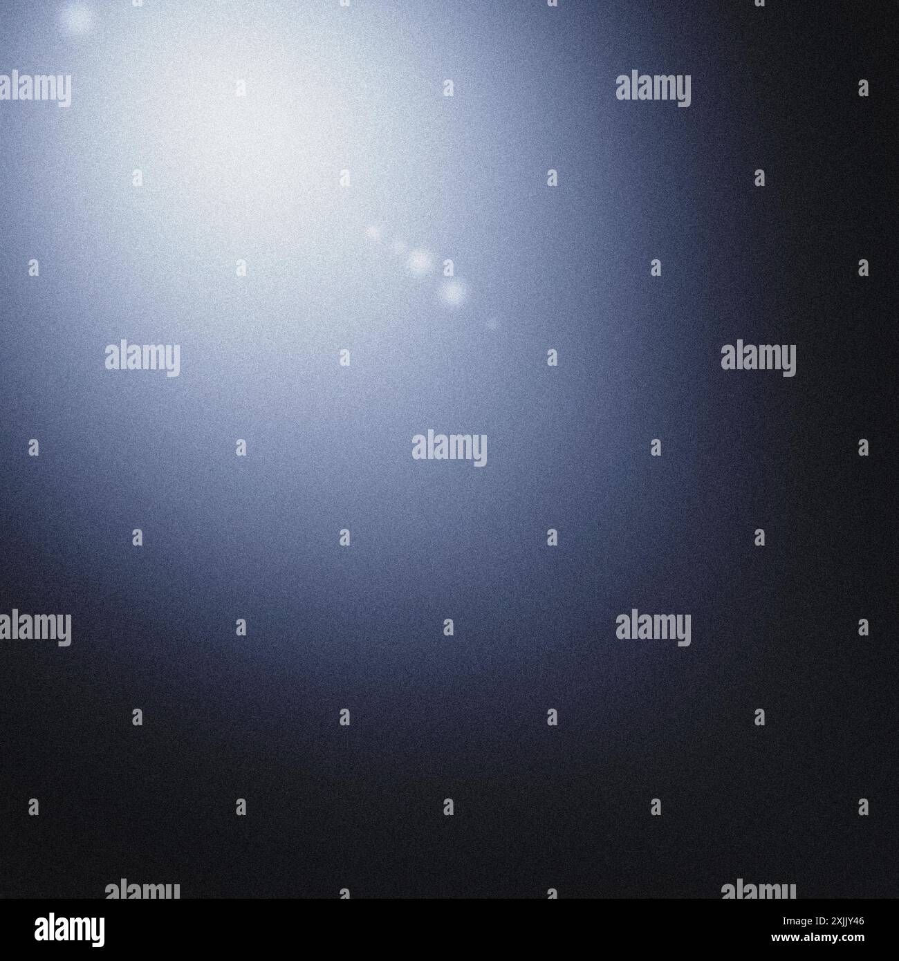 Bright light beam illuminating a blue studio backdrop with space for text Stock Photo