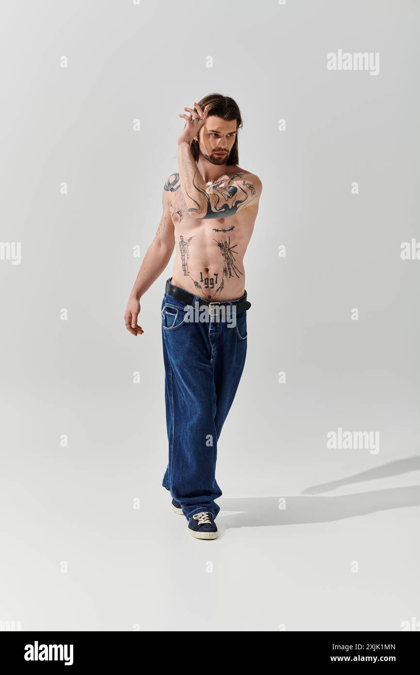 Handsome man with body tattoos walking in trendy attire. Stock Photo