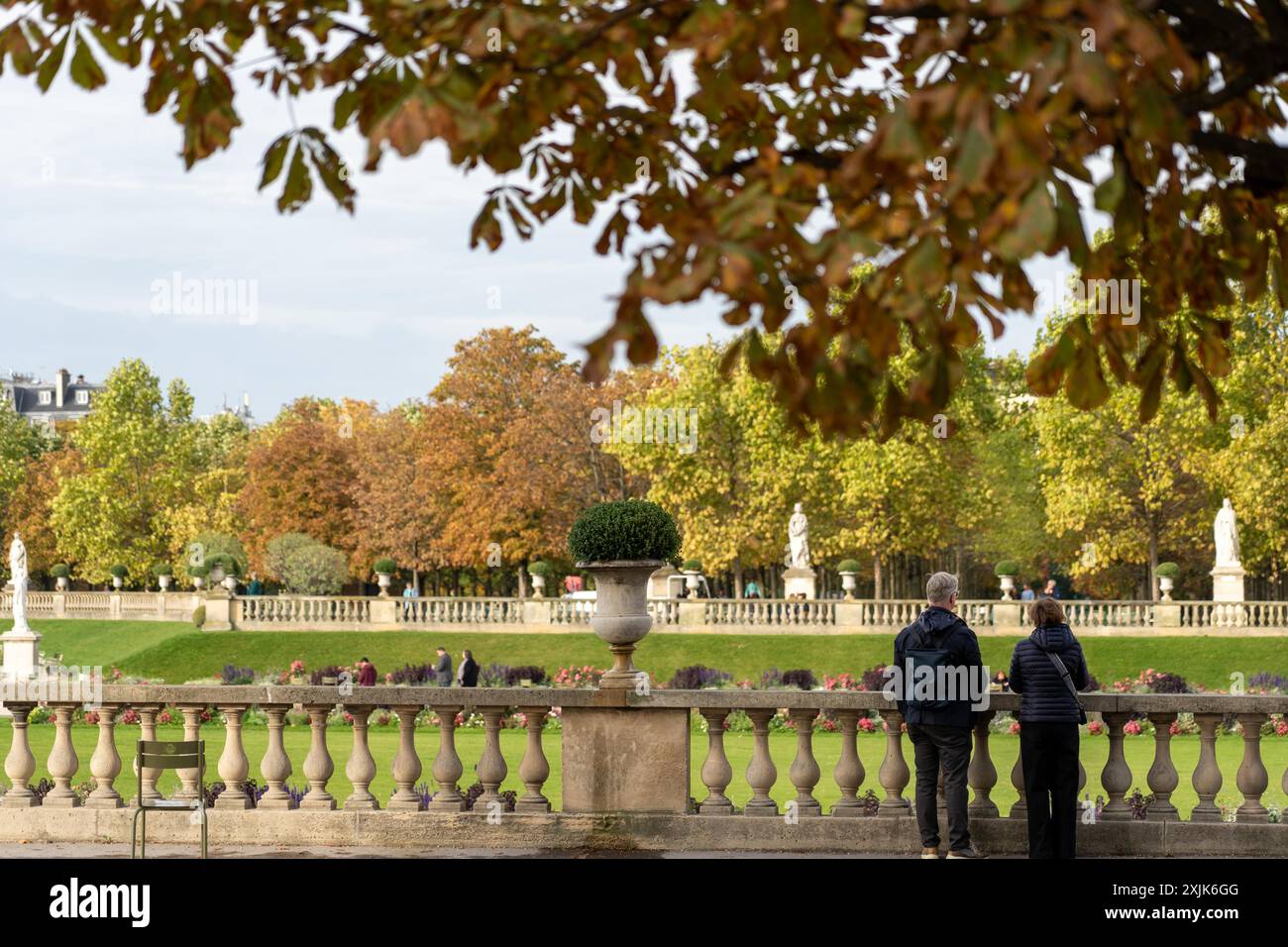 Paris, France - October 18, 2023 : A couple stands at a stone railing ...