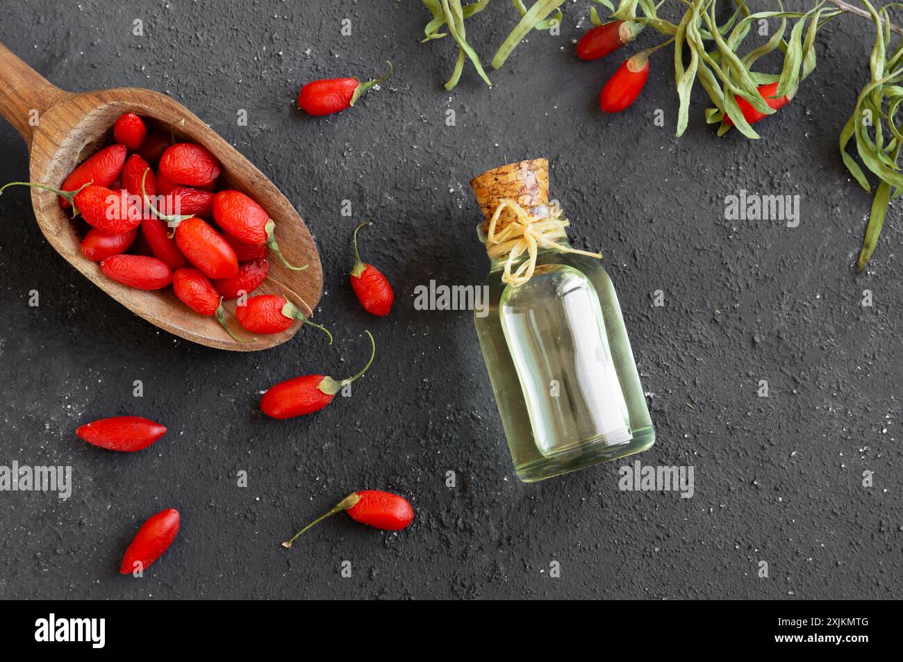 Glass bottle of goji berry oil with fresh goji berries, Lycium barbarum Stock Photo