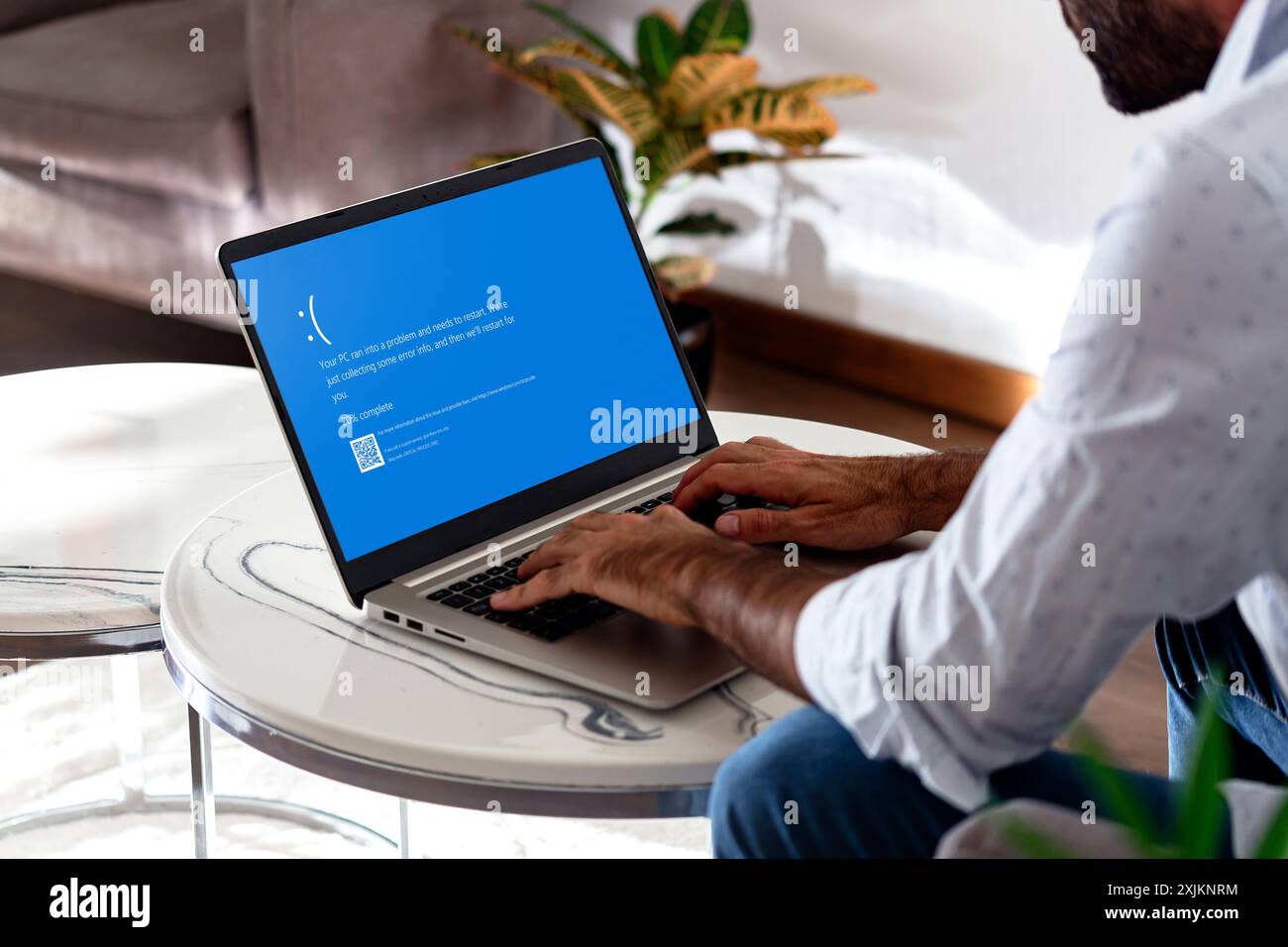 Man with laptop showing Blue screen of death or BSOD on the monitor screen. Faulty Microsoft operating system Windows 10. Rosario, Argentina - July 19 Stock Photo