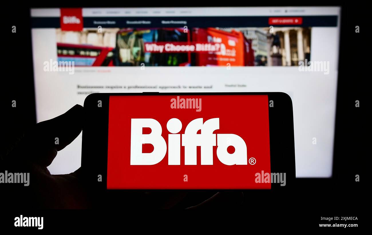 Stuttgart, Germany, 06-11-2022: Person holding mobile phone with logo of British waste management company Biffa plc on screen in front of web page. Stock Photo