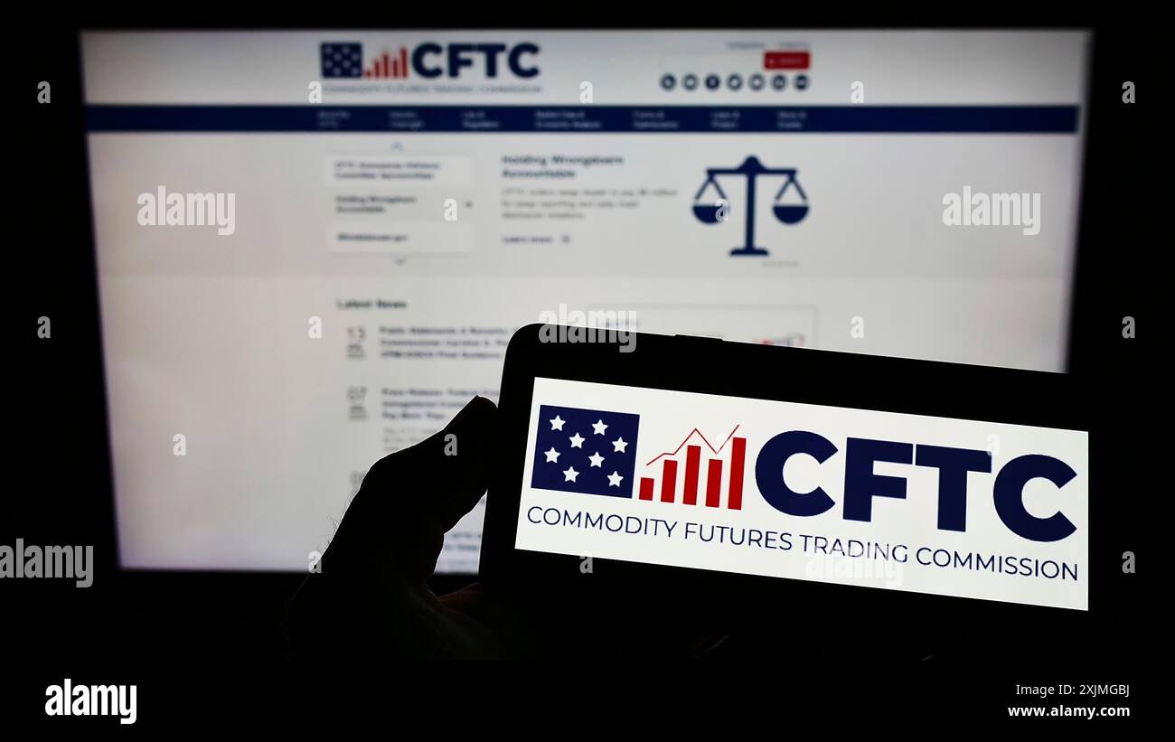 Stuttgart, Germany, 07-13-2022: Person holding smartphone with logo of US Commodity Futures Trading Commission (CFTC) on screen in front of website. Stock Photo