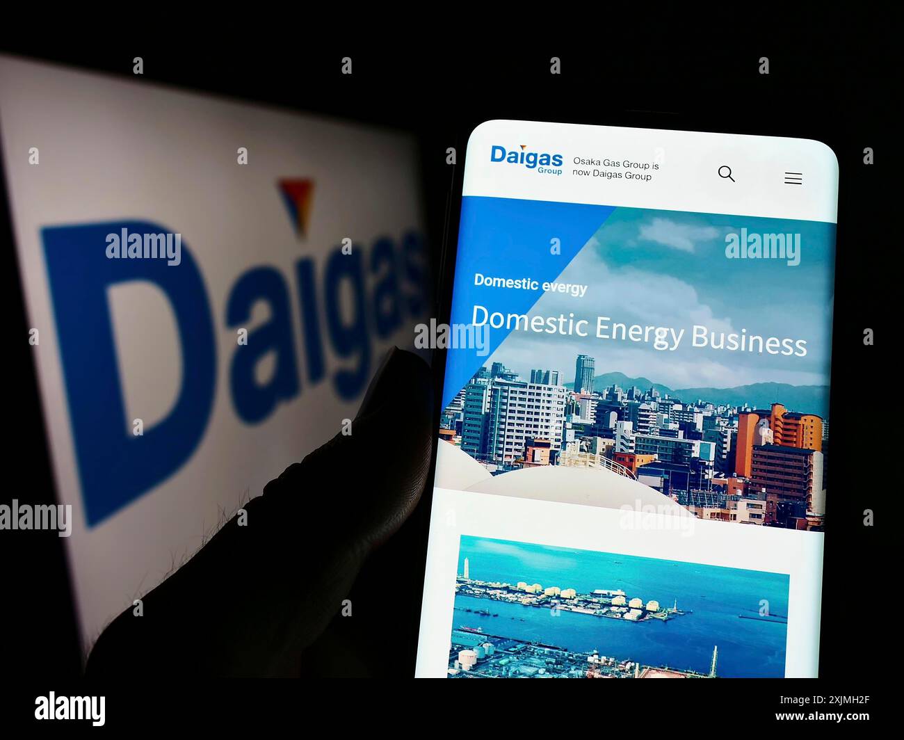 Stuttgart, Germany, 07-16-2022: Person holding cellphone with website of Japanese energy company Daigas Group (Osaka Gas) on screen with logo. Focus Stock Photo