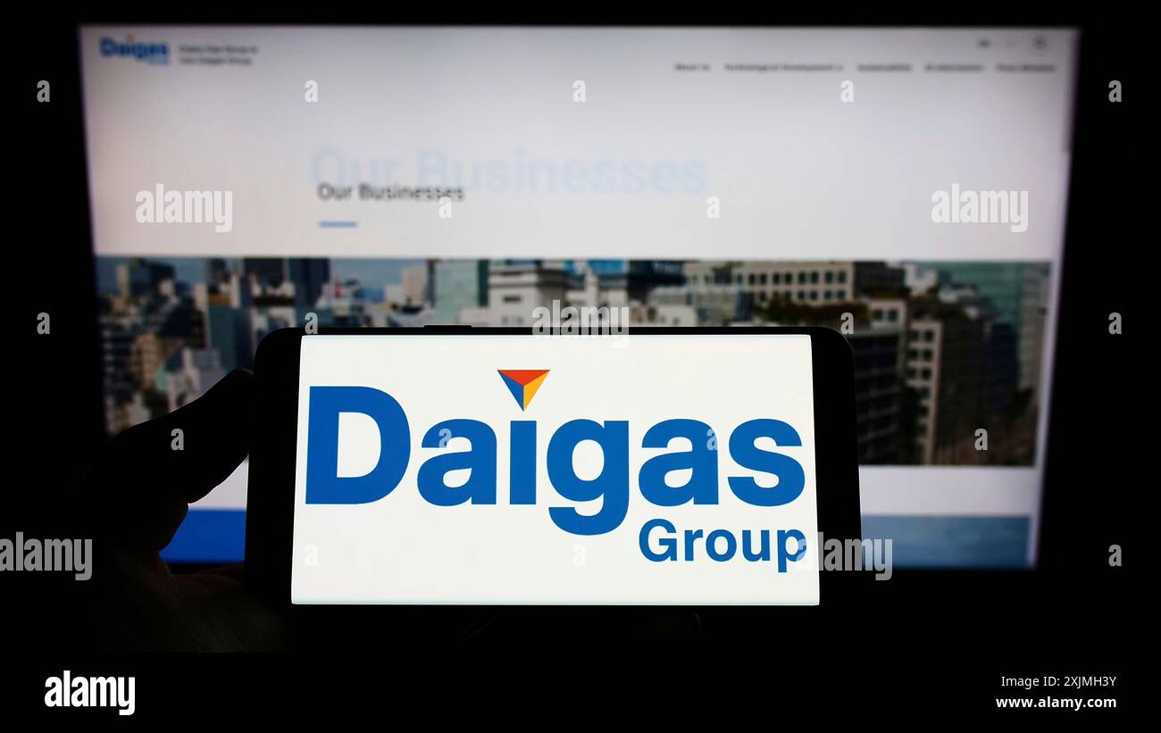 Stuttgart, Germany, 07-16-2022: Person holding smartphone with logo of Japanese energy company Daigas Group (Osaka Gas) on screen in front of Stock Photo