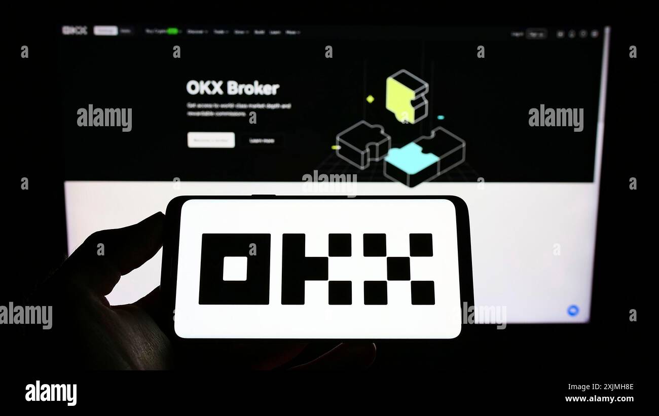 Stuttgart, Germany, 07-17-2022: Person holding cellphone with logo of crypto company Aux Cayes FinTech Co. Ltd. (OKX) on screen in front of webpage. Stock Photo
