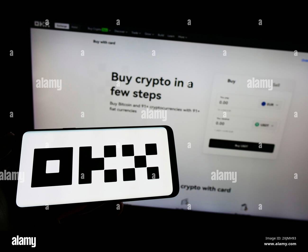 Stuttgart, Germany, 07-17-2022: Person holding smartphone with logo of crypto company Aux Cayes FinTech Co. Ltd. (OKX) on screen in front of website. Stock Photo
