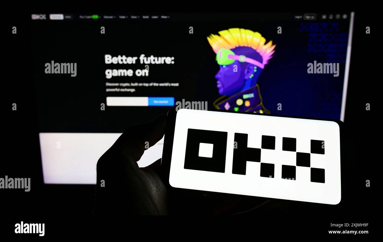 Stuttgart, Germany, 07-17-2022: Person holding mobile phone with logo of crypto company Aux Cayes FinTech Co. Ltd. (OKX) on screen in front of web Stock Photo