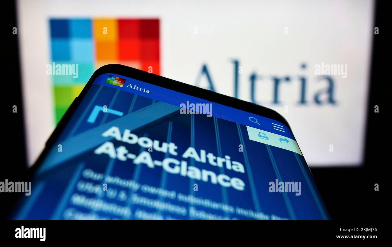 altria tobacco company Smartphone with website of US tobacco company Altria Group Inc. on screen  in front of business logo. Focus on top-left of phone display Stock Photo