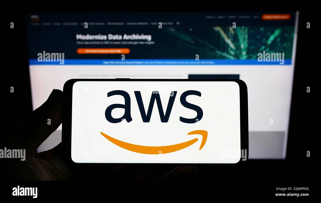Stuttgart, Germany, 10-01-2022: Person holding smartphone with logo of US cloud company Amazon Web Services Inc. (AWS) on screen in front of website. Stock Photo