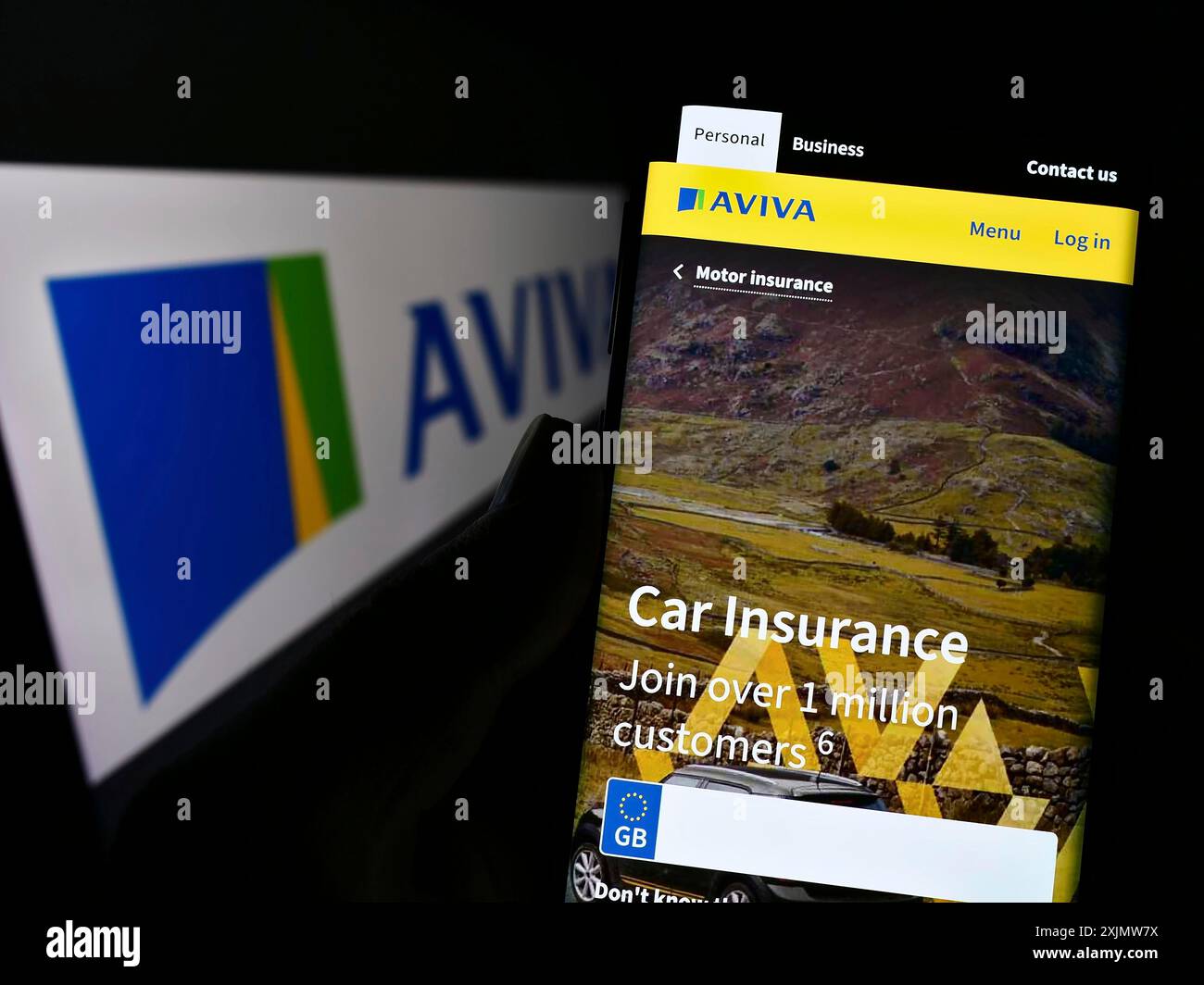 Stuttgart, Germany, 11-30-2022: Person holding smartphone with website of British insurance company Aviva plc on screen in front of logo. Focus on Stock Photo