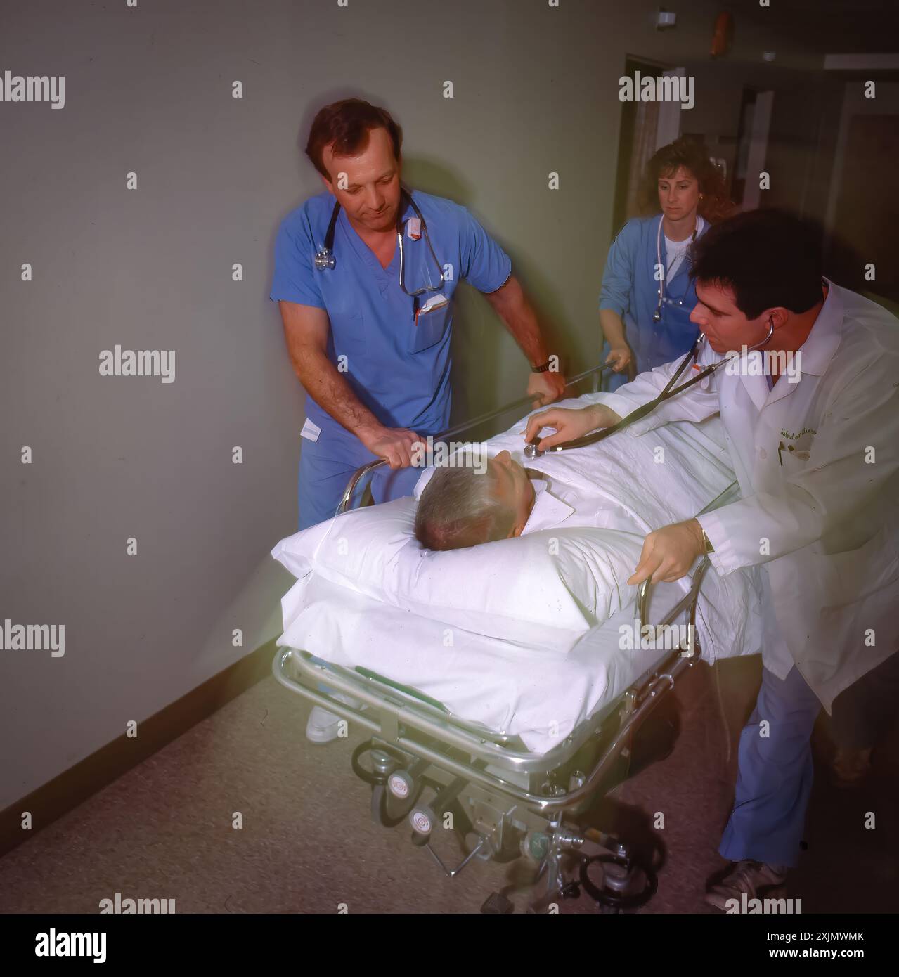 Doctor Rushing Patient In Medical team rushing patient on gurney through hospital corridor ...