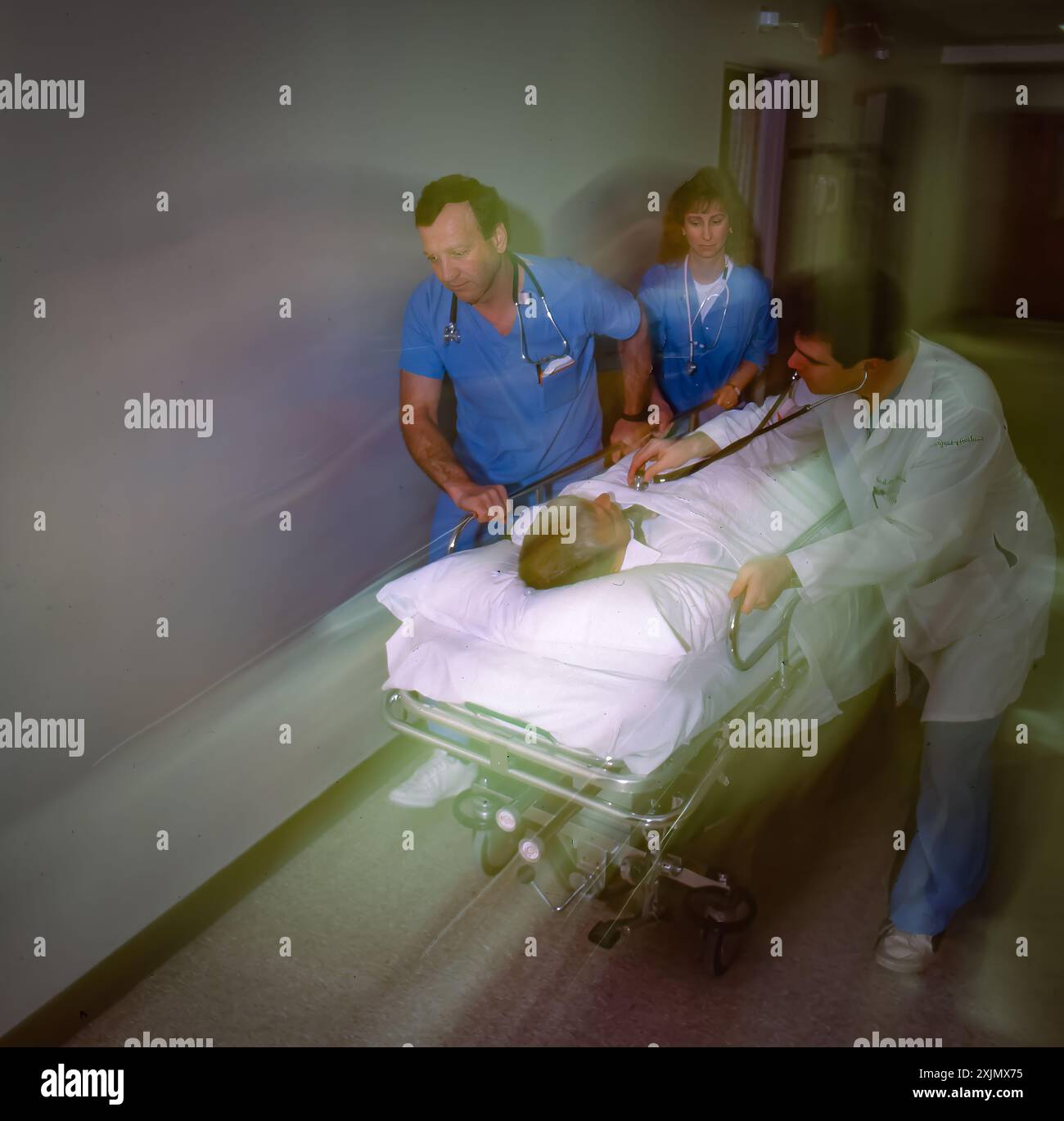 Patient Rushed Medical team rushes patient on gurney through hospital corridor ...