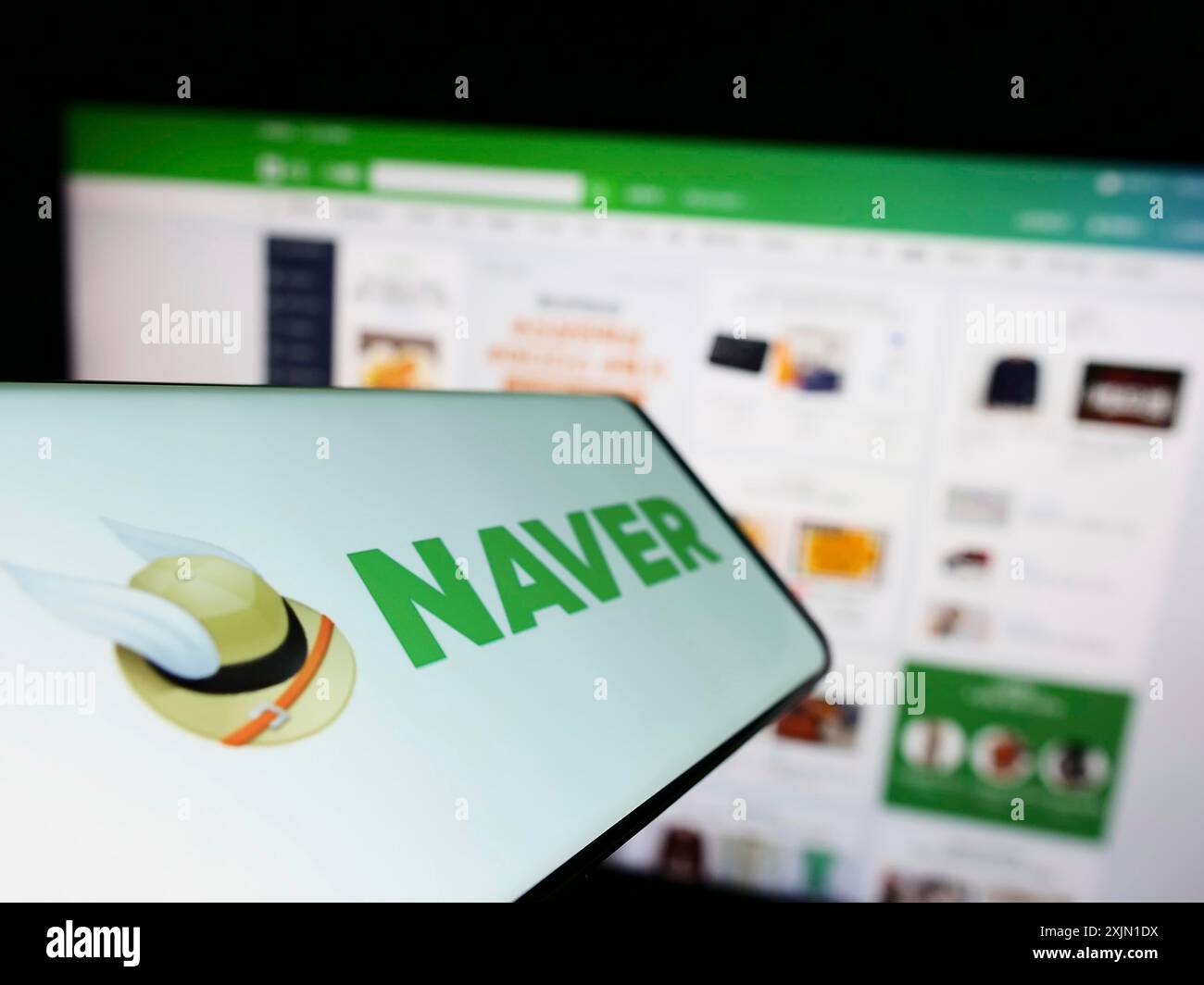 Stuttgart, Germany, 01-14-2023: Cellphone with logo of search engine company Naver Corporation on screen in front of business website. Focus on Stock Photo