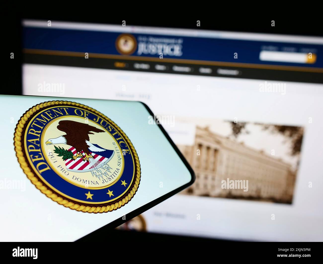 Stuttgart, Germany, 04-19-2023: Mobile phone with seal of United States Department of Justice (DOJ) on screen in front of website. Focus on Stock Photo