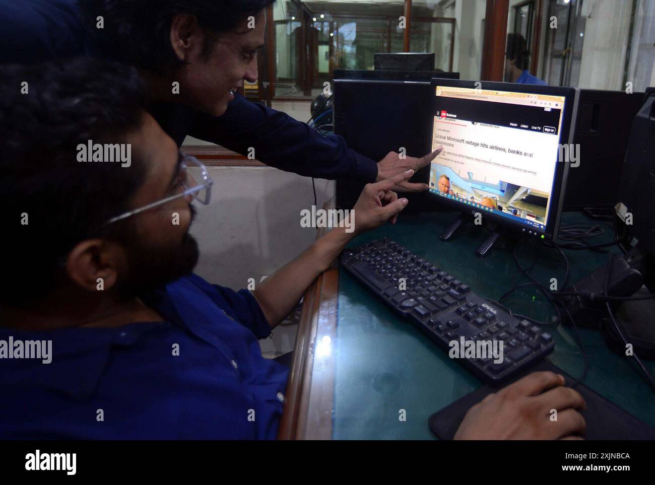 A man reads news of Microsoft global outage on a computer screen in
