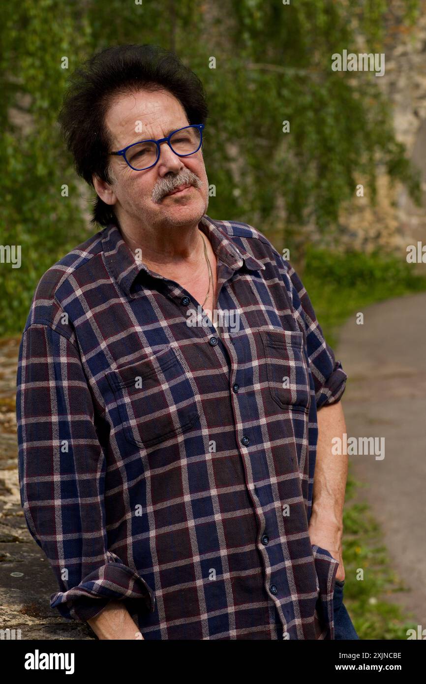 Good looking man with glasses in front of a stone wall. Stock Photo